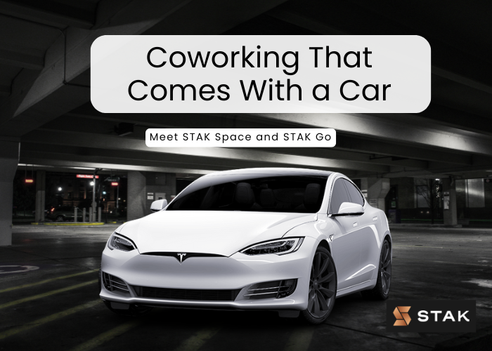 A sleek white Tesla parked in a modern, well-lit garage, symbolizing the innovative STAK GO program that combines coworking with car-sharing