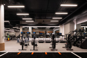 State-of-the-art fitness center at STAK Space with treadmills, rowing machines, weightlifting equipment, and modern lighting