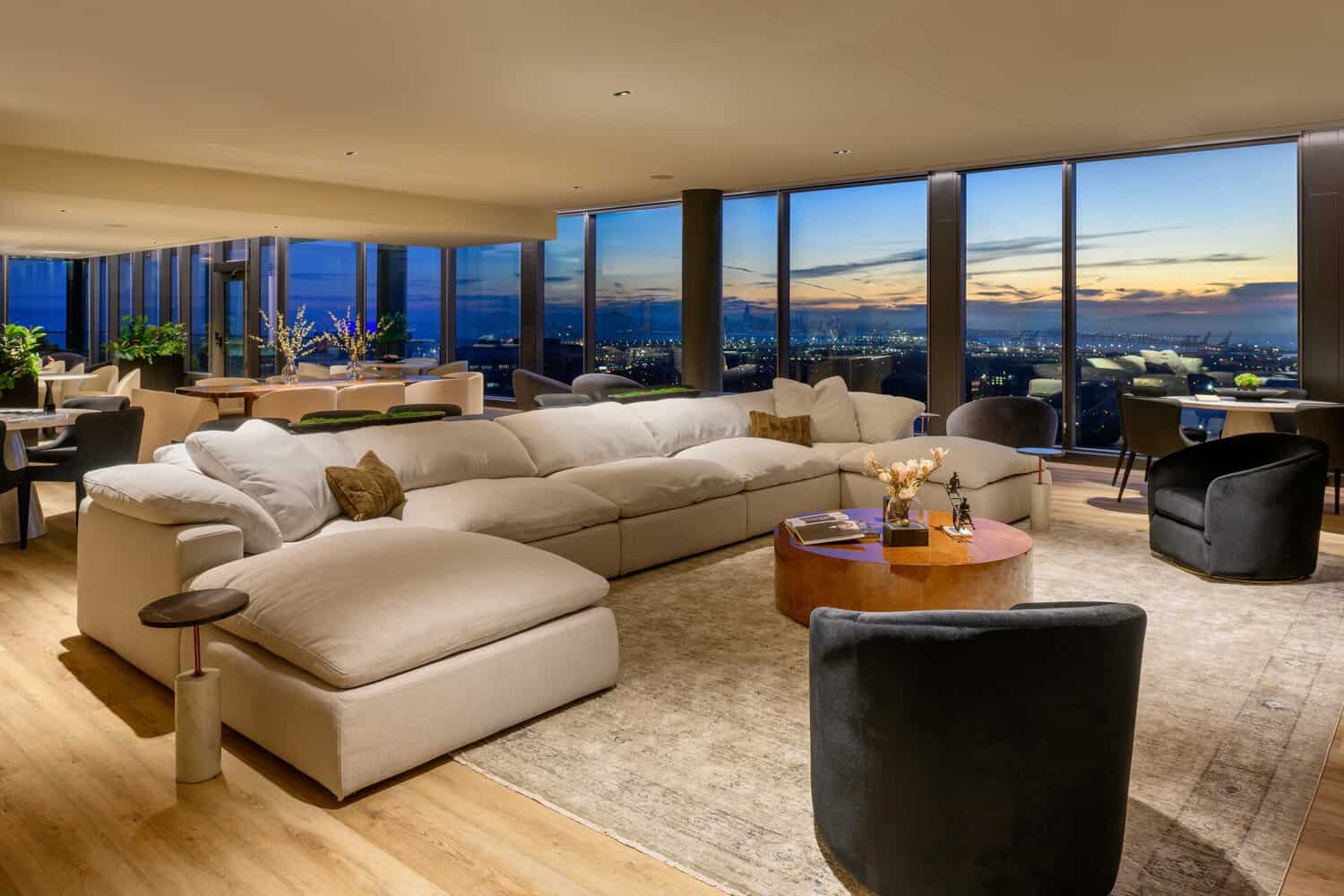 Penthouse lounge at 1900 Broadway with sectional seating and panoramic views over Oakland