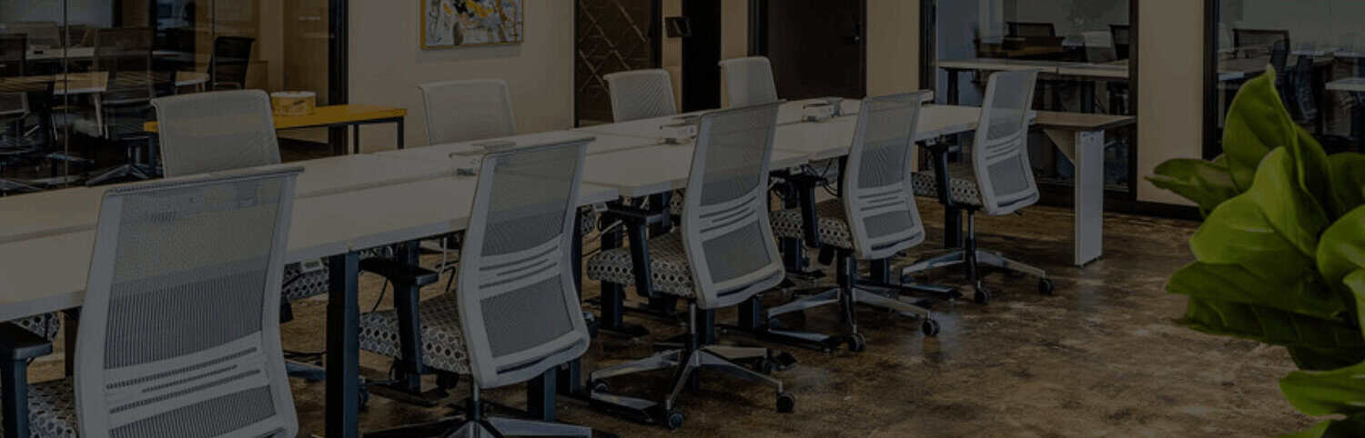Coworking floor with rows of desks at STAK Space on the 1900 Broadway Campus