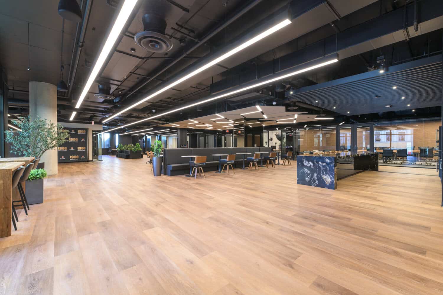 Full coworking floor with open lounge, shared tables and floor-to-ceiling windows at 1920 Broadway