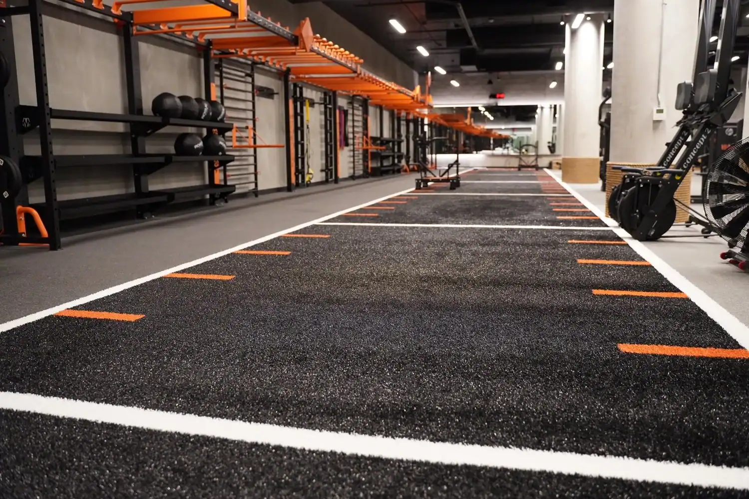 Indoor turf lane for sled pushes and agility drills in the STAK Space fitness center