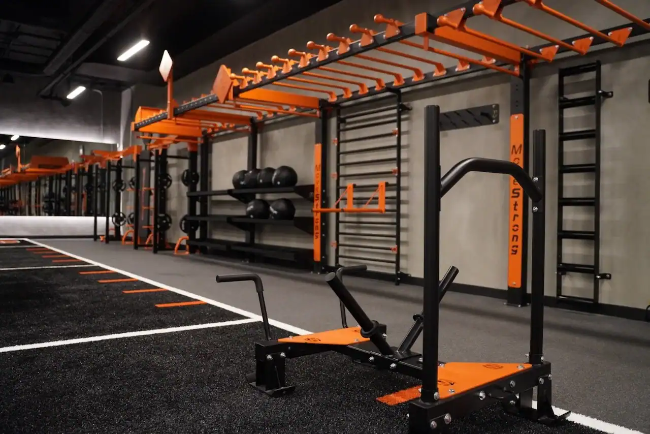 Fitness center amenity at 1900 Broadway with orange MoveStrong training rigs, turf lanes and sleds
