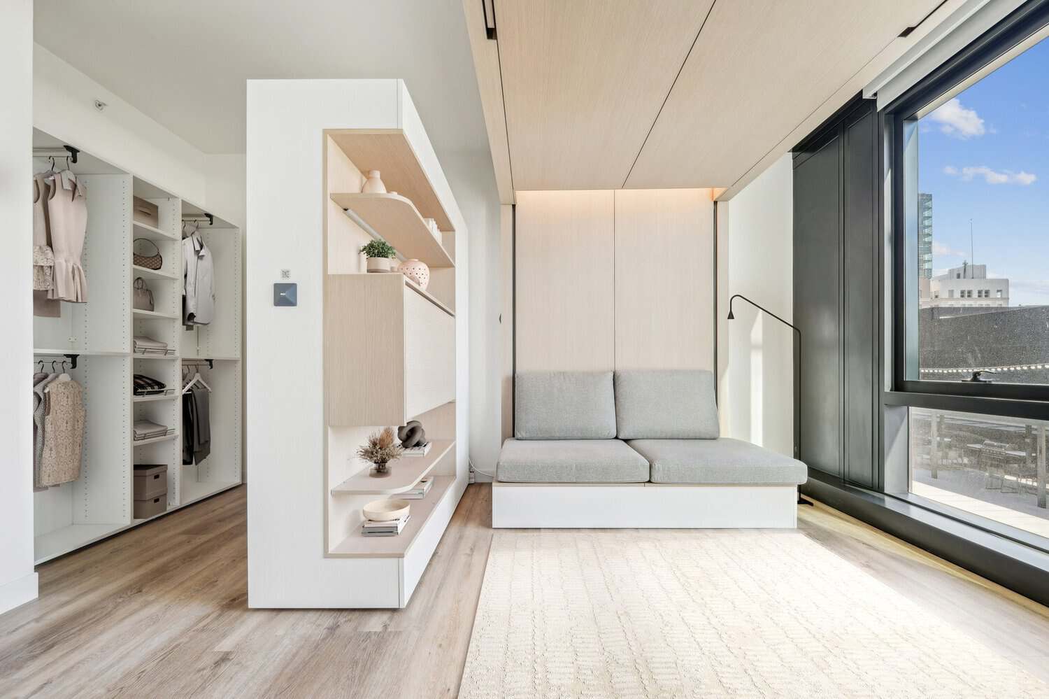 Furnished co-living room with an Ori Pocket Closet and sofa at 1900 Broadway