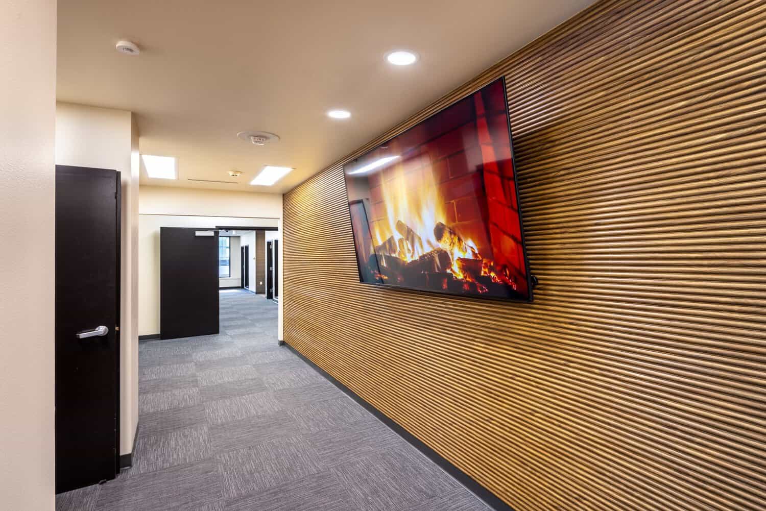 Office suite entry with a sculpted wood media wall at 1950 Franklin, Oakland