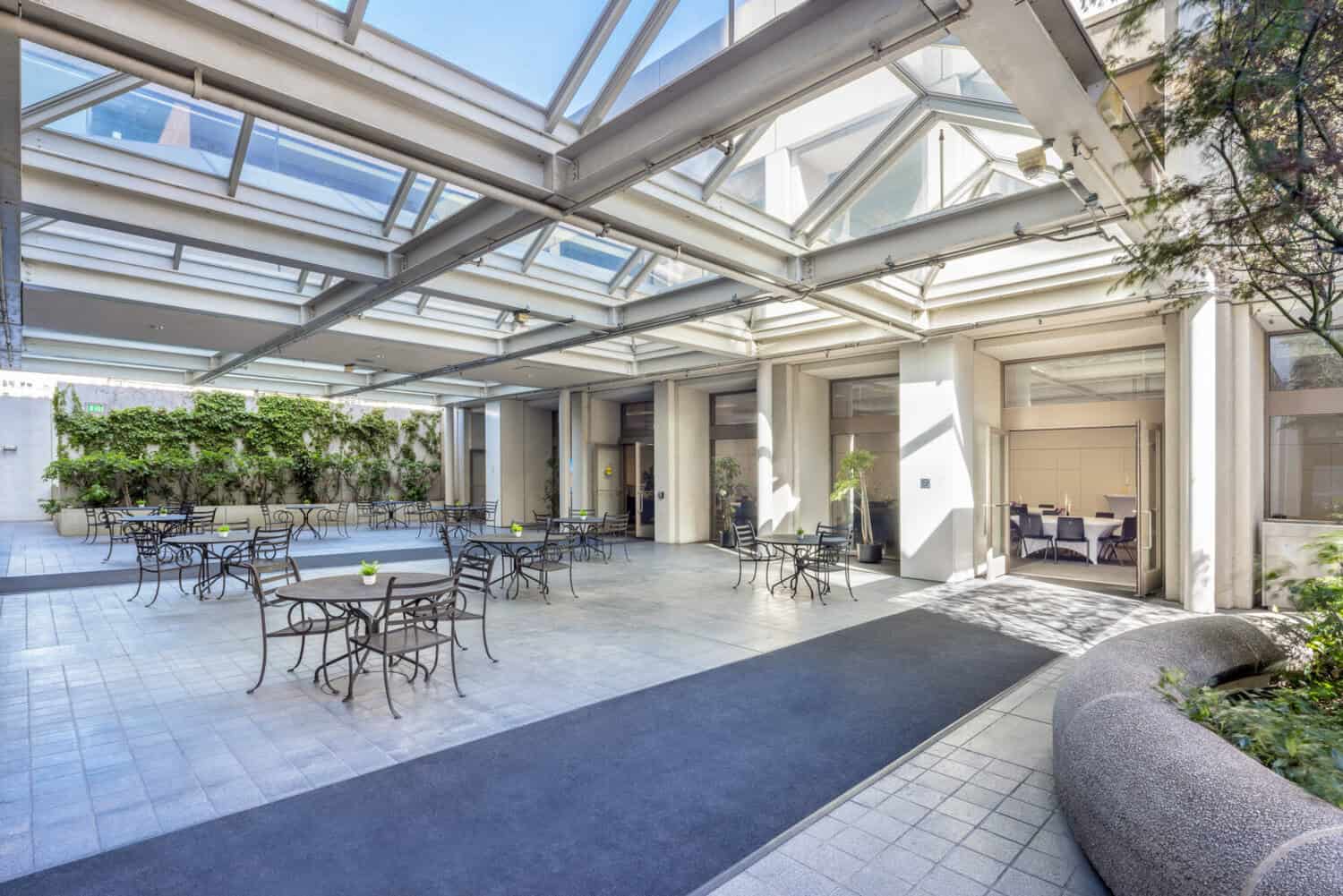 Skylit dining terrace with café tables at 1950 Franklin