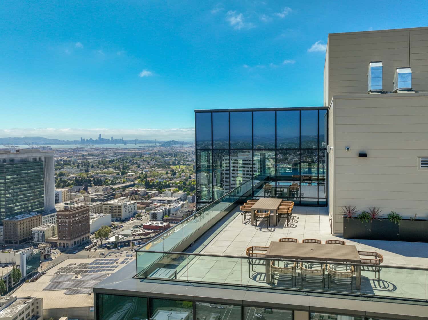 Rooftop patio with seating and umbrellas above Oakland at 1900 Broadway