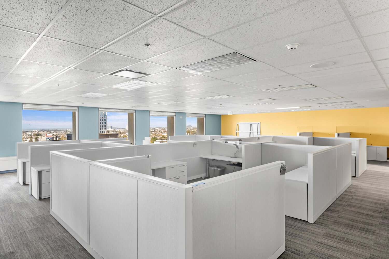 Vintage cubicle office floor with drop ceiling, colored accent walls and city views at 1950 Franklin